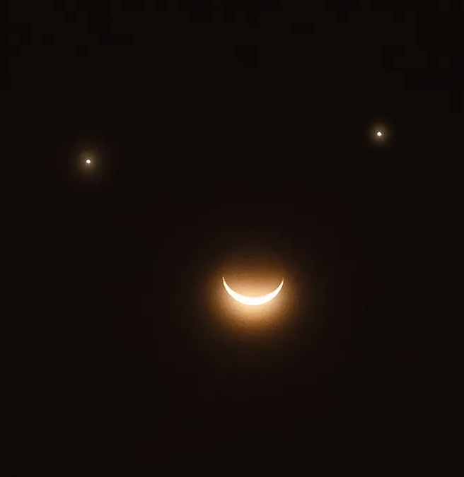 ExploreCosmos_'s tweet photo. On the morning of Friday, April 25, 2025, a rare celestial event known as a triple conjunction will occur, where Venus, Saturn, and the crescent moon will align closely in the predawn sky, forming a triangular pattern resembling a smiley face. This alignment will be visible near the eastern horizon just before sunrise, around 5:30 a.m. local time, with the sun rising approximately an hour later.

Venus and Saturn will appear as bright points of light, easily visible to the naked eye, while the crescent moon will form the “smile” beneath them. For optimal viewing, it’s recommended to find a location with a clear view of the eastern horizon. Additionally, Mercury may be visible below the trio, though it will be very low in the sky and might not be observable from all locations.

This event is part of a series of notable astronomical occurrences in April 2025, including the Lyrid meteor shower, which peaks just days before the conjunction.

Orbital paths: The planets and the Moon follow predictable paths (the ecliptic) across the sky. Occasionally, they appear near each other due to their positions in their orbits aligning closely as seen from Earth.

Perspective: The "smiley face" is an illusion based on our line of sight. Venus and Saturn will be bright dots (the "eyes"), and the thin crescent moon, curved upward, looks like a smile.

Timing: This specific configuration only occurs for a brief period,  just before sunrise on April 25,  because of how quickly the Moon moves across the sky and the relative motions of the planets.