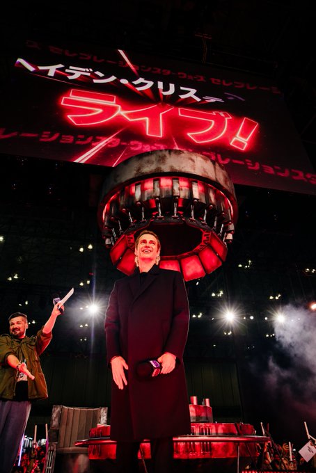 Hayden Christensen poses in red lighting on the LIVE! Stage in front of Anthony Carboni.
