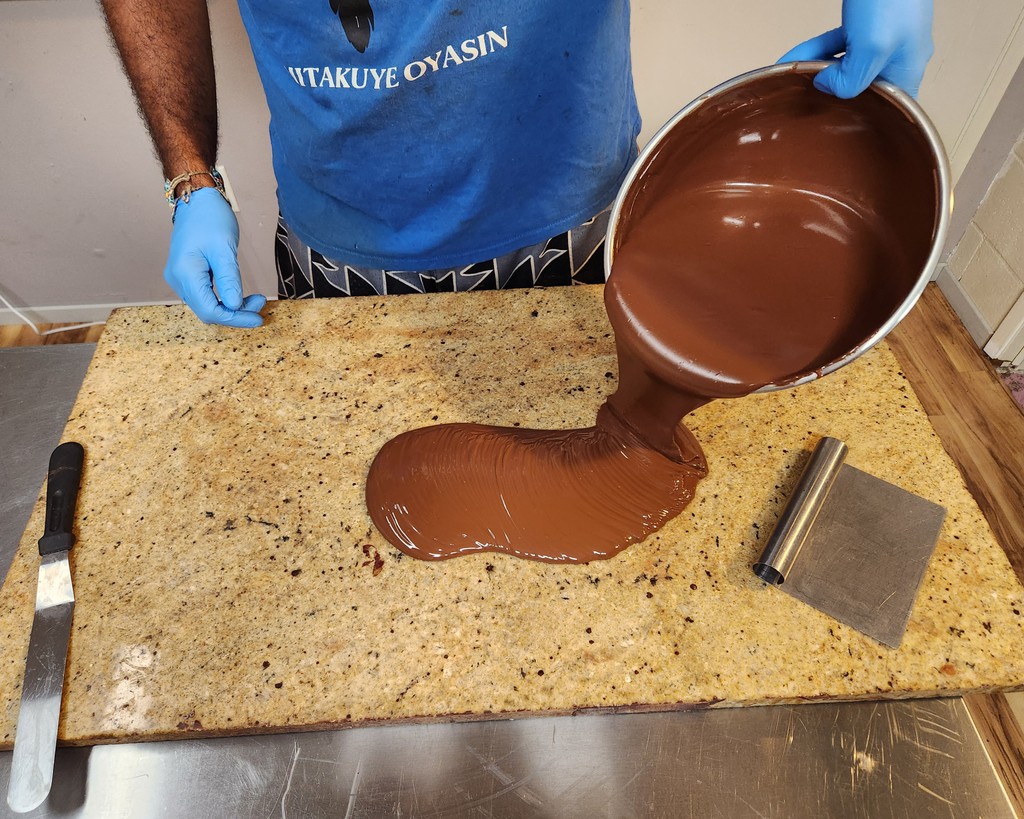 When tempered chocolate cools, it has a crisp snap and glossy sheen. Here, Valley Isle’s co-founder and chocolate maker Samual Schwartzkopf uses the tabletop tempering method.