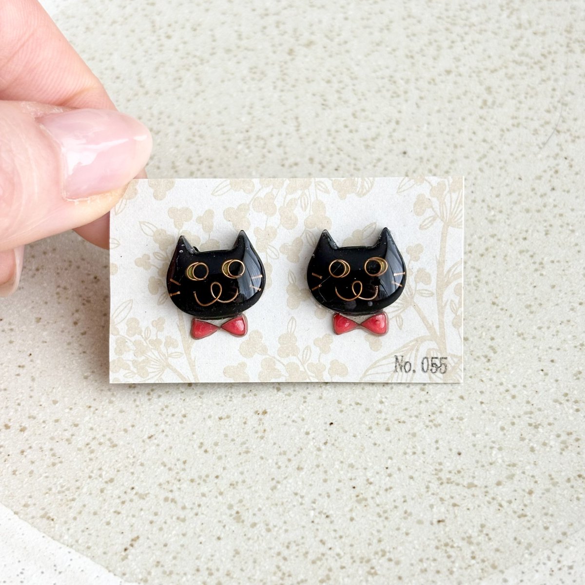 No0556's tweet photo. 【No.055】ニャンコ　猫　ピアス　ハチワレ　黒猫　赤蝶ネクタイ❤️

ニャンコの大きさは2×1.5センチのニャンコです。
１つずつ手作りで、針金を曲げて表情を作り、色付け、コーティングを重ねています。
1点ずつ顔が違いますので在庫は各1個のみです^_^

ポスト含む金具はサージカルステンレス😊 https://t.co/2tvRDQWlrQ
