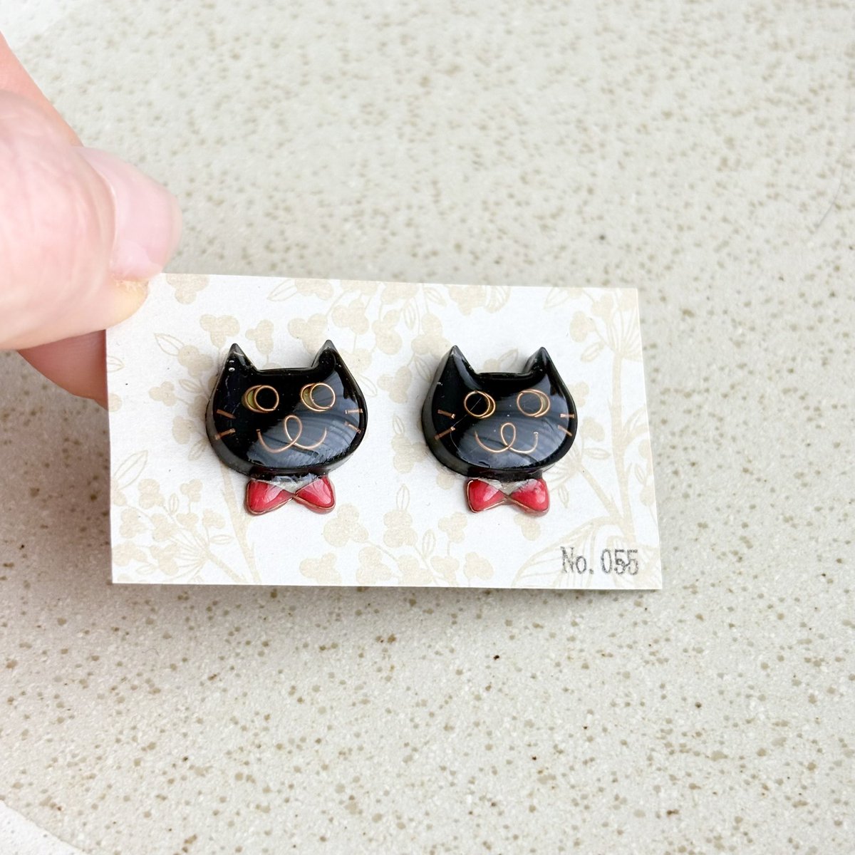 No0556's tweet photo. 【No.055】ニャンコ　猫　ピアス　ハチワレ　黒猫　赤蝶ネクタイ❤️

ニャンコの大きさは2×1.5センチのニャンコです。
１つずつ手作りで、針金を曲げて表情を作り、色付け、コーティングを重ねています。
1点ずつ顔が違いますので在庫は各1個のみです^_^

ポスト含む金具はサージカルステンレス😊 https://t.co/2tvRDQWlrQ