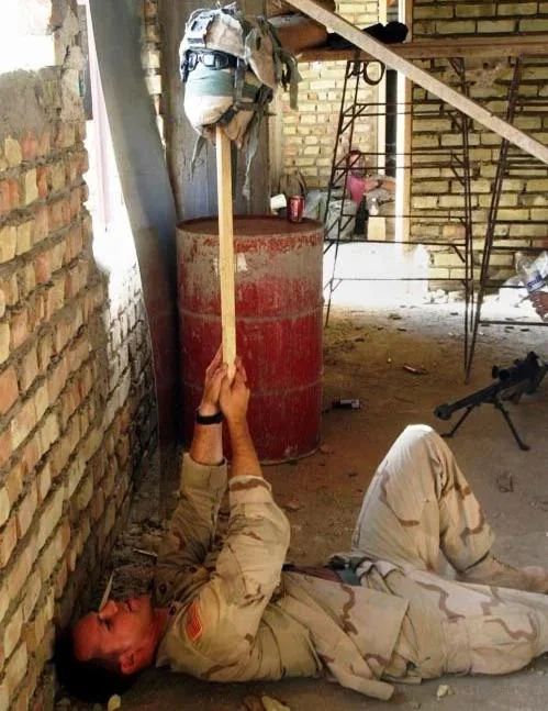 Photo of a U.S. sniper using his helmet as a decoy to find the enemy's position in Najaf, Iraq. August 2004.