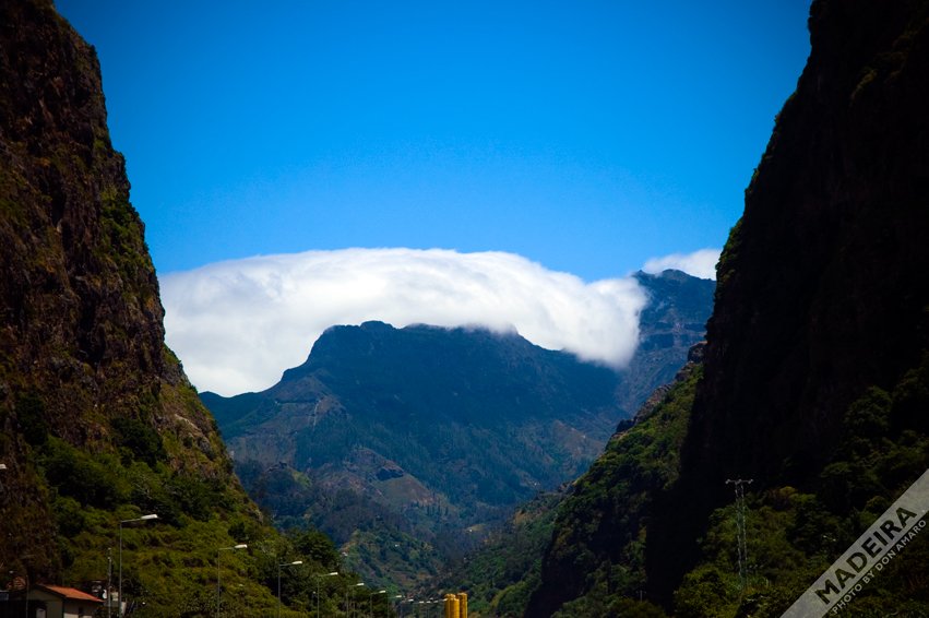 Madeira's tweet photo. #Madeira 

The mountains of Madeira play a key role in what’s known as the orographic effect. When moist air from the ocean is pushed upward by the island's steep slopes, it cools rapidly, leading to condensation and the formation of clouds. This is why you often see clouds hanging low over the mountains, as depicted in the X post image where a thick layer of fog or cloud is seen rolling over the peaks. The web result mentions how the mountains, often rising above 1,400 meters, "block the gusts and clouds," causing them to accumulate on the windward side, particularly in the north.