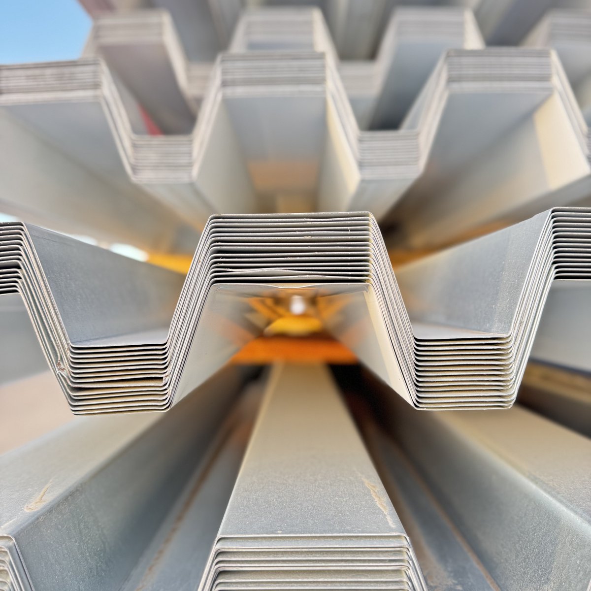 BorgesArch's tweet photo. Stacks of steel beams, rebar and spiral duct might seem like pure function, but look closer—there’s an art to construction. Lines intersect, shadows shift, and patterns emerge in the organized chaos of building. The materials themselves tell a story of transformation. https://t.co/p9u5xG2VTp