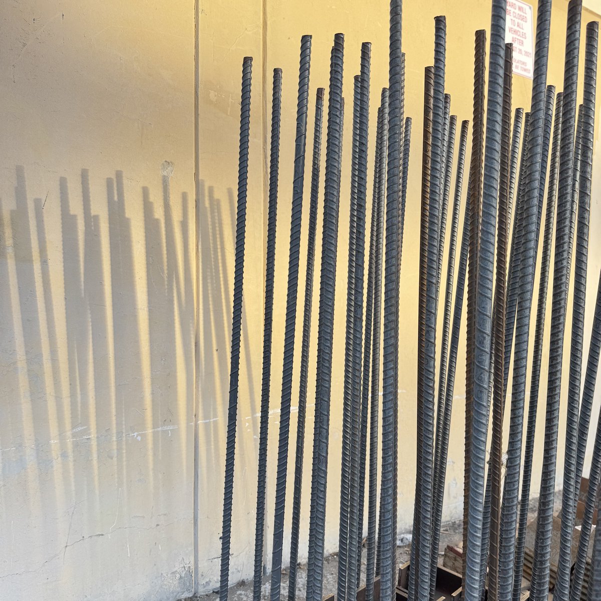 BorgesArch's tweet photo. Stacks of steel beams, rebar and spiral duct might seem like pure function, but look closer—there’s an art to construction. Lines intersect, shadows shift, and patterns emerge in the organized chaos of building. The materials themselves tell a story of transformation. https://t.co/p9u5xG2VTp