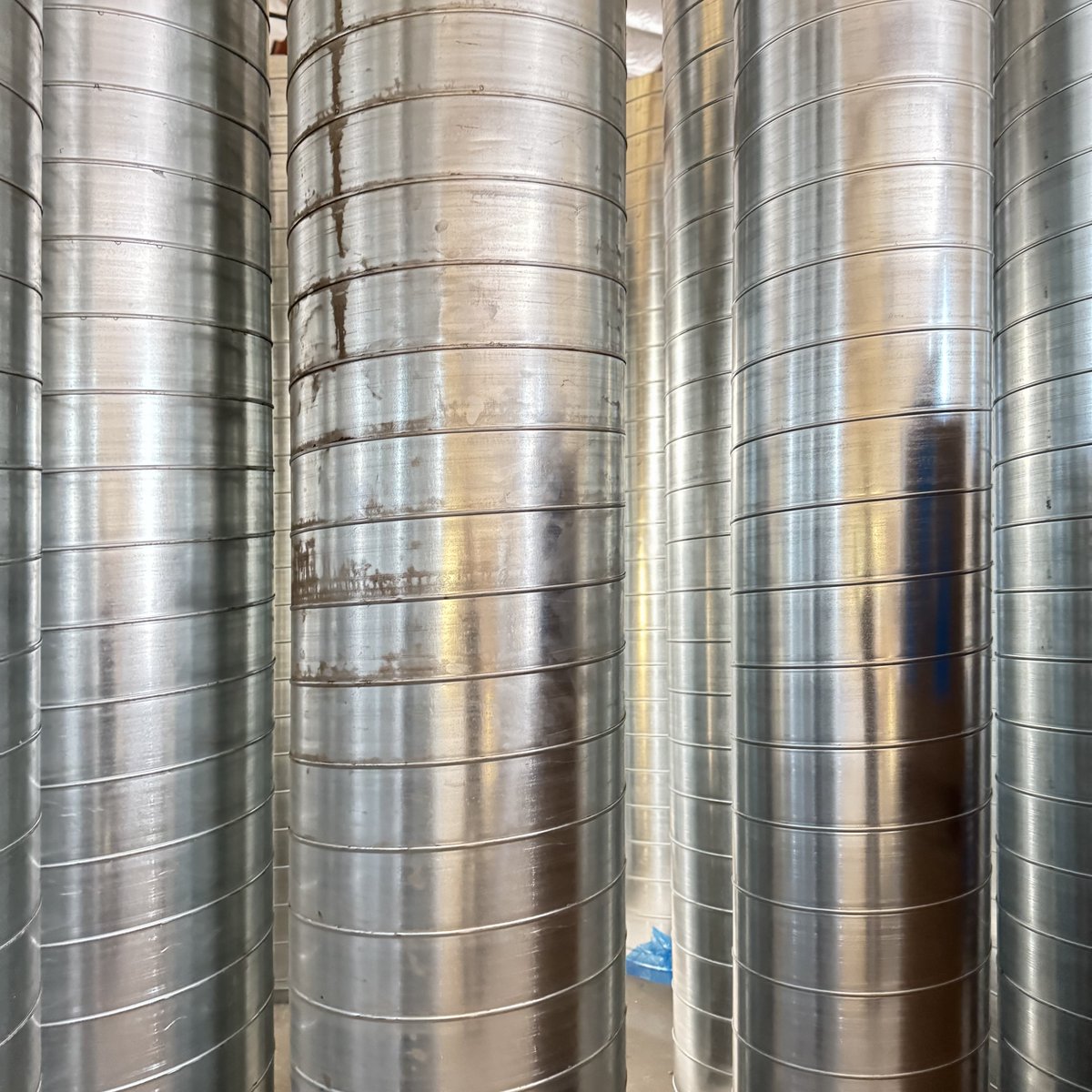BorgesArch's tweet photo. Stacks of steel beams, rebar and spiral duct might seem like pure function, but look closer—there’s an art to construction. Lines intersect, shadows shift, and patterns emerge in the organized chaos of building. The materials themselves tell a story of transformation. https://t.co/p9u5xG2VTp