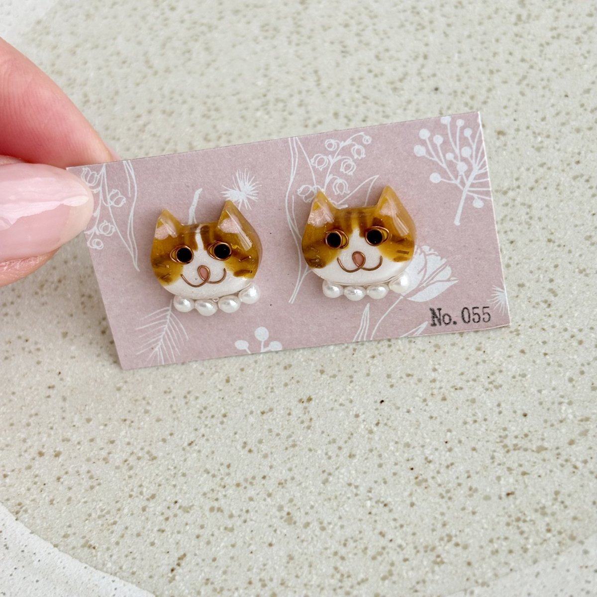 No0556's tweet photo. 【No.055】ニャンコ　猫　ピアス　ハチワレ　茶白　パール首輪
パール首輪の大ぶり感が可愛い😍

ニャンコの大きさは2×1.5センチのニャンコです。
１つずつ手作りで、針金を曲げて表情を作り、色付け、コーティングを重ねています。
1点ずつ顔が違いますので在庫は各1個のみです^_^ https://t.co/DF6uWwe9VV