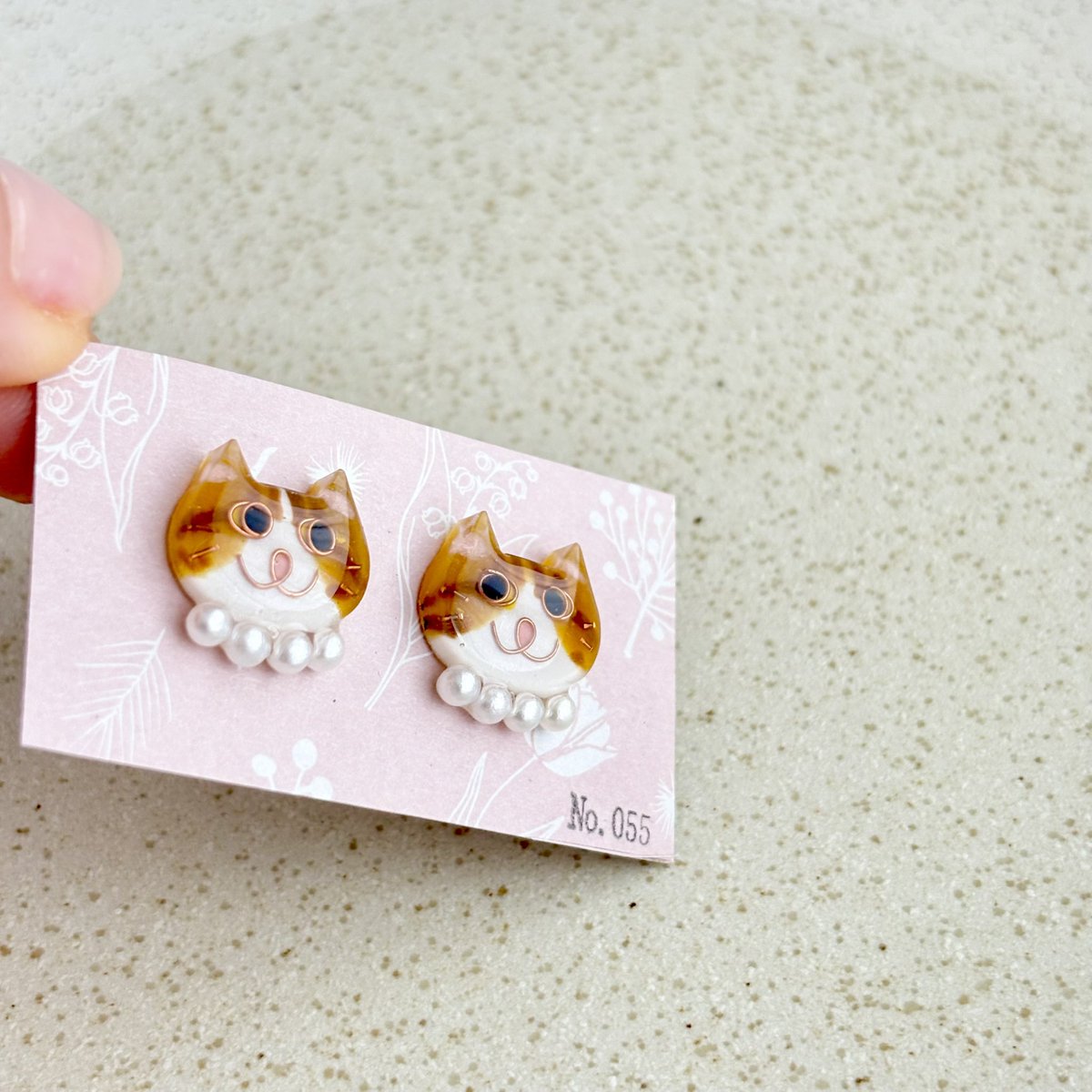 No0556's tweet photo. 【No.055】ニャンコ　猫　ピアス　ハチワレ　茶白　パール首輪
パール首輪の大ぶり感が可愛い😍

ニャンコの大きさは2×1.5センチのニャンコです。
１つずつ手作りで、針金を曲げて表情を作り、色付け、コーティングを重ねています。
1点ずつ顔が違いますので在庫は各1個のみです^_^ https://t.co/DF6uWwe9VV