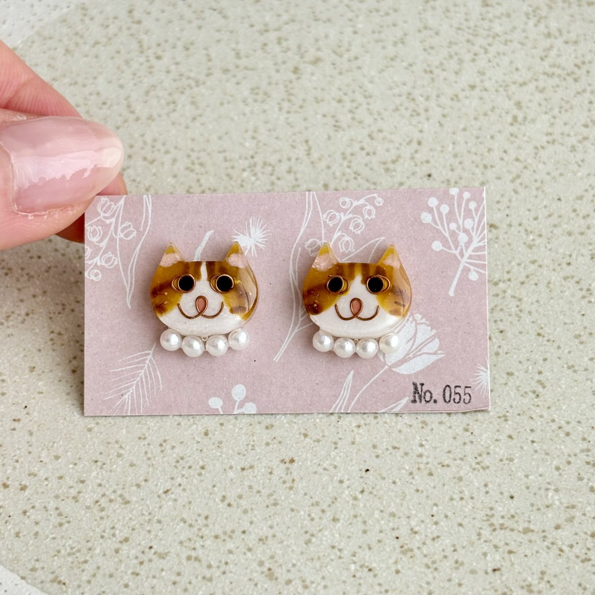 No0556's tweet photo. 【No.055】ニャンコ　猫　ピアス　ハチワレ　茶白　パール首輪
パール首輪の大ぶり感が可愛い😍

ニャンコの大きさは2×1.5センチのニャンコです。
１つずつ手作りで、針金を曲げて表情を作り、色付け、コーティングを重ねています。
1点ずつ顔が違いますので在庫は各1個のみです^_^ https://t.co/DF6uWwe9VV