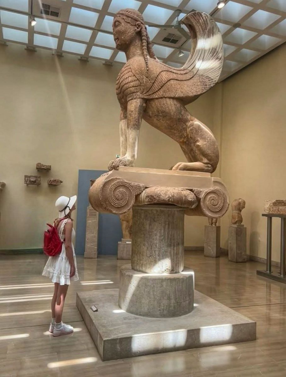 archeohistories's tweet photo. The most famous Oracle of the ancient world was located at Delphi in Mainland Greece. The Oracle of Delphi was dedicated to Apollo, god of Light and Harmony. For over 1,000 years, pilgrims from all over the Mediterranean travelled to Delphi to receive the prophecies of  Apollo through the words of the priestess. It was such a renowned religious site that all the “Great Powers” of the times would erect a monument  to demonstrate their wealth and power to all visitors.

During 6th Century BC, Naxos was one of the most prosperous Greek islands due to its strategic location in the center of the Aegean Sea combined with  the island’s  natural resources, such as water, farm land, marble quarries, emery mines and more. Thanks to the abundance of marble in the Cyclades, the Naxians soon developed excellent skills in carving marble into works of art  which were eventually displayed at the most famous sanctuaries of the ancient world. And, the Oracle of Delphi was included in the list.

The Oracle of Delphi required some necessary operational procedures  to facilitate the process of delivering prophecies. Whenever Pythia -the head priestess- was scheduled to chew the laurel leaves, inhale the hallucinogenic vapors coming from deep  fissures in the earth and begin murmuring words, petitioners should wait in line for order of admission. In continuation, her words would take the form of prophecies with the help of the male priests of the sanctuary.

However, there was always a way to get a higher place in the line…perhaps by offering a major gift to the oracle? Oh yes, and this is the case with the massive Naxian Sphinx statue. The representatives of Naxos wanted to get the privilege of “promanteia”, which means to become eligible to consult the Oracle first whenever they needed to do so. Therefore, their offering to Apollo’s sanctuary was a 2 meter statue of a Sphinx standing majestically on a 10 meter Ionic column. The Naxian Sphinx was placed close to the “rock of the Sibyl” at a clearly visible spot along the Sacred Way- the marble road which led the pilgrims to Apollo’s temple. The selection of this prominent location symbolized the political, financial and artistic superiority of Naxos island in the Archaic period.

But why a Sphinx and not another majestic work of art?

The Sphinx was a very popular theme during this period connected to the Egyptian culture which  shared close trade ties with Greece  at that time. A Sphinx was a mythical creature with the head of a woman, the body of a lioness, the tale of a serpent and the wings of an eagle. Sphinx statues were considered to have ferocious strength and were considered as guardians often flanking the entrances to temples. Specifically, the Sphinx of the Naxians was placed very close to the most sacred spot of Delphi, where Apollo had presumably killed the Python. This impressive archaic relief dates to 560 BC, which coincides with the peak period of Naxian artistic production. The monument was made from a solid piece of Naxian marble and its transport still remains an admirable accomplishment. The statue was transferred  all the way from Naxos to the Oracle of Delphi…crossing the Aegean Sea into the Corinthian Gulf and continuing on an upward  overland route climbing  Mt. Parnassus, from the shore to the site of the Oracle.

Today, the original art is housed  in the Delphi Museum and a modern replica stands proudly  in front of the Naxos Town Hall facing the emblematic “Portara”- all that remains of Apollo’s Temple facing the Sacred Island of Delos, birthplace of the god.

#archaeohistories