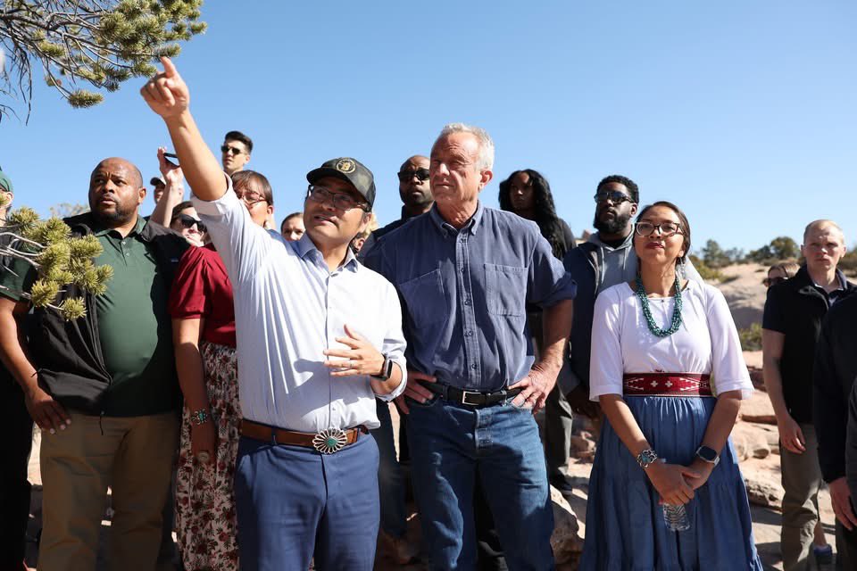 BuuVanNygren's tweet photo. SECRETARY OF HEALTH ROBERT F. KENNEDY JR. VISITS NAVAJO NATION

WINDOW ROCK, Ariz. — Against the backdrop of the iconic Window Rock arch, Navajo Nation President Buu Nygren sat on a sandstone cliff with U.S. Secretary of Health and Human Services Robert F. Kennedy Jr. and Council Delegate Germaine Simonson to discuss critical healthcare access issues facing the Navajo people—and the solutions rooted in sovereignty, tradition, and self-reliance.

Secretary Kennedy, on a national tour, made a significant stop on the Navajo Nation to meet with tribal leaders including President Nygren, First Lady Jasmine Blackwater-Nygren, Speaker Crystalyne Curley, members of the 25th Navajo Nation Council, and officials from the Navajo Department of Health. The purpose of the visit was to better understand how Navajo programs are maximizing federal resources to serve thousands of Navajo people across the Nation.

"I know that you're no stranger to Navajo," President Nygren told Secretary Kennedy. "With your support and help, we will build the Gallup Indian Medical Center because it is in such, such need. It will expand to where we do not have to go to Albuquerque or Phoenix and our people will have a world-class facility."

The visit was deeply personal for Secretary Kennedy, who last set foot on the Navajo Nation 60 years ago alongside his father. His return began with a sunrise hike with tribal leaders from the base of the tribal capital to Window Rock. They were met with sacred prayer, traditional songs by a medicine healer, and ceremonial dances performed by the Dinétah Dancers at the Navajo Veterans Memorial Park.

President Nygren provided additional context about the urgent health disparities on the Nation and the strain caused by the Indian Health Service’s 30 percent vacancy rate.

“As President, I want to emphasize the importance of protecting and maintaining tribal sovereignty among food and healthcare for the Navajo Nation,” President Nygren said.

Secretary Kennedy expressed strong support, making a clear commitment to address staffing shortages and cuts in the Indian Health Service.

“By lifting the IHS hiring freeze and rescinding the hundreds of employee terminations,” Secretary Kennedy said, “it will not happen.”

Secretary Kennedy emphasized that the federal government must go further to empower Native communities.

"Today we learned many things that HHS could be doing to improve the condition of Navajo health...,” he said, adding that securing water will allow the Navajo people to build homes and become self-sustaining again.

A focal point of Secretary Kennedy’s visit was the Navajo Nation’s pioneering of the junk food tax, formally known as the Healthy Diné Nation Act. Passed in 2014 through grassroots mobilization by the Diné Community Advocacy Alliance, the law promotes healthy lifestyles and combats rising rates of diabetes and obesity.

The Indian Health Service reports that one in five Navajo Nation residents lives with diabetes, and approximately 75,000 individuals are prediabetic.

Revenues from the junk food tax have been redirected to support community wellness projects through the Navajo Division of Community Development, according to the Office of the Navajo Tax Commission.

President Nygren also emphasized the need for formal tribal consultations to ensure that the trust and treaty responsibilities are upheld, especially as recent changes at the federal level have impacted social services.

“We strive to live for 102 years as Navajo people, and also with your help and assistance, we look forward to reestablishing and protecting some of the services that your department provides,” President Nygren told Secretary Kennedy.

President Nygren added, “Secretary Kennedy’s visit today shows that our voices are being heard at the highest levels. We’re not asking for charity, we’re reaffirming equity, and we’re building solutions grounded in sovereignty…the Navajo Nation is ready to lead.”