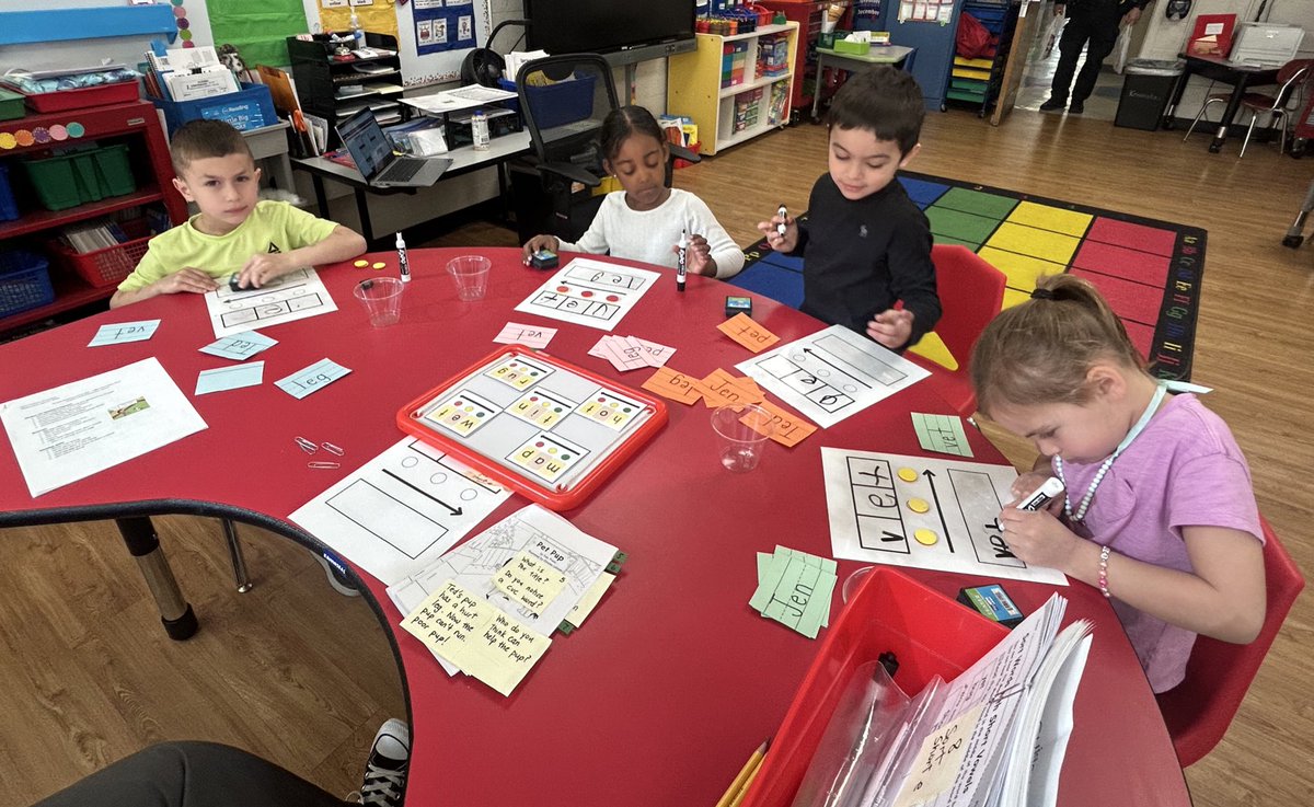 A VRS kindergarten strategy group dives into vowel sounds using decodable readers. They are building confidence, fluency, and a love for reading