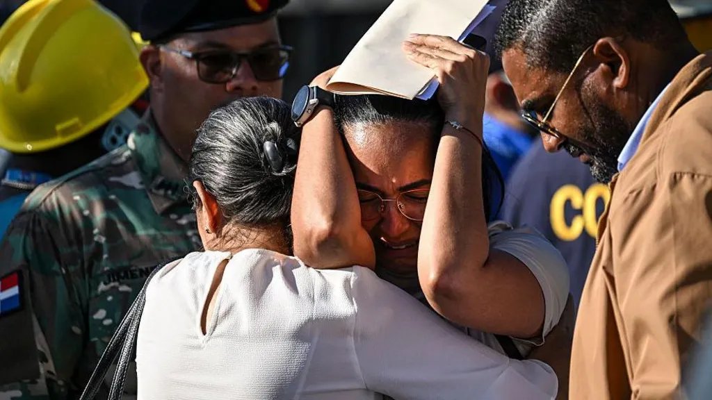AnimeAlchemy24's tweet photo. 2/ Girl, 17, whose dad is lost in nightclub rubble spends birthday at scene

Máximo Peña, a regular at the Jet Set nightclub for 30 years, attended a concert with his wife and sister, but tragically, they are now among the 184 confirmed dead after the roof collapsed during the event. His daughter, 17-year-old Shailyn Peña, anxiously awaits news of her missing family members while rescue teams search through the rubble.

Despite the efforts of over 300 rescue workers, including international teams, the government announced that the search for survivors would soon transition to recovery efforts. The tragedy has led to three days of national mourning in the Dominican Republic, with notable figures among the deceased, including singer Rubby Pérez and former baseball players.

As rescue operations continue, questions arise about the nightclub's structural integrity, especially concerning a fire two years prior. Shailyn, who has learned about her family's fate from schoolmates, faces her birthday under tragic circumstances, highlighting the profound impact of this disaster on her and many others.