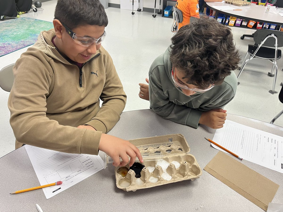 Fifth graders observing chemical reactions and recording results! 🥽