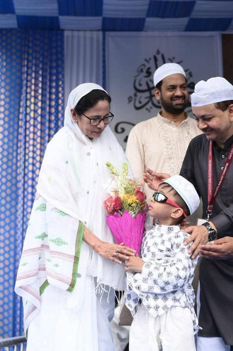 Nationalist2575's tweet photo. Zoom in. The man holding the child's shoulder has a tag hanging from his neck it reads "Kolkata Khilafat Committee"  Do you know what is Khilafat?  - Establishment of Muslim rule by destroying non-Muslims is called Khilafat. And the CM is encouraging it. She feels no shame! https://t.co/EPuz600Sr3