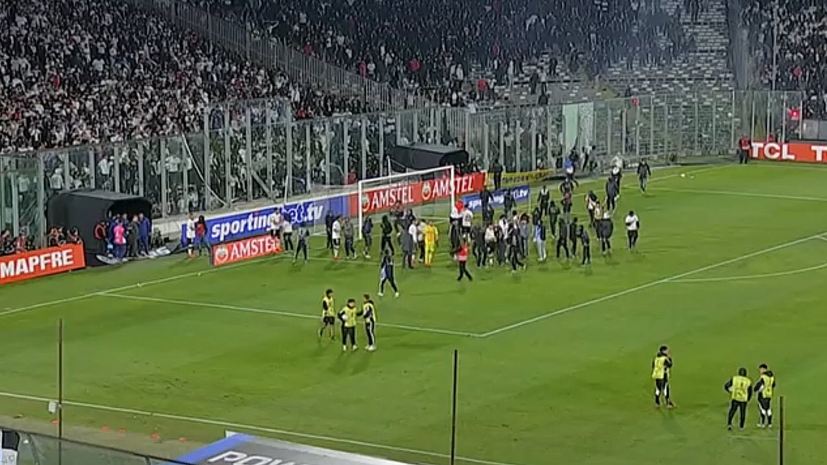 Cooperativa's tweet photo. [MARCADOR VIRTUAL ⚽] ¡Se descontroló todo! Los hinchas de Colo Colo ya ingresaron al campo y empiezan a manifestarse por las dos personas fallecidas en la antesala del encuentro #CooperativaContigo https://t.co/TJFTjP8lt6 https://t.co/jn5E02u6Mu
