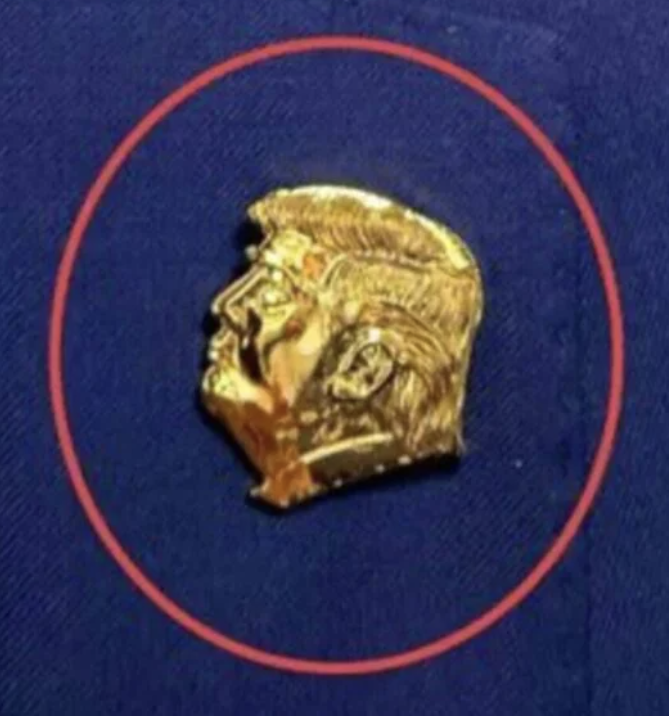FCC Chair Brendan Carr sports a gold Trump-head lapel pin.

Members of Trump’s cabinet, along with Congresspeople and Senators, are being instructed to wear a tribute to their inglorious, convicted-felon leader.