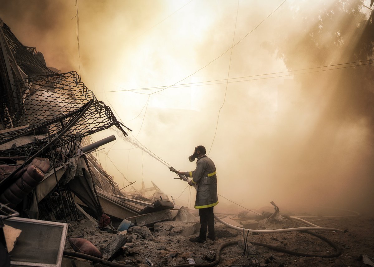 motazazaiza9's tweet photo. Palestinian fireman is trying to put out a fire caused by an Israeli air strike that destroyed a residential tower in Gaza city.

A lot of times there was no water or even fire trucks to control the fire that caused by Israeli air strikes, As Israeli occupation destroyed most of civil defense crafts and stations.

Photo by Motaz Azaiza.