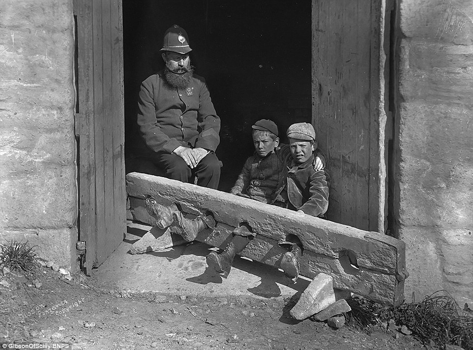 İki genç arkadaş ve küçük hırsızlar ceza olarak prangaya vurulmuş. 
Old Street, Londra, İngiltere, 1900 civarı