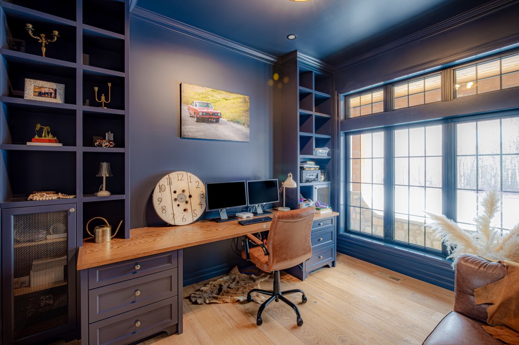 Bears Paw Project - This blue office is the perfect blend of focus and inspiration. The rich hue creates a sense of depth and sophistication, while the large windows bring in natural light.

Interior Design: <a href="/rcid_/">Rochelle Cote</a>
Build: @wideskyhomes
Photo: @wideskyhomes