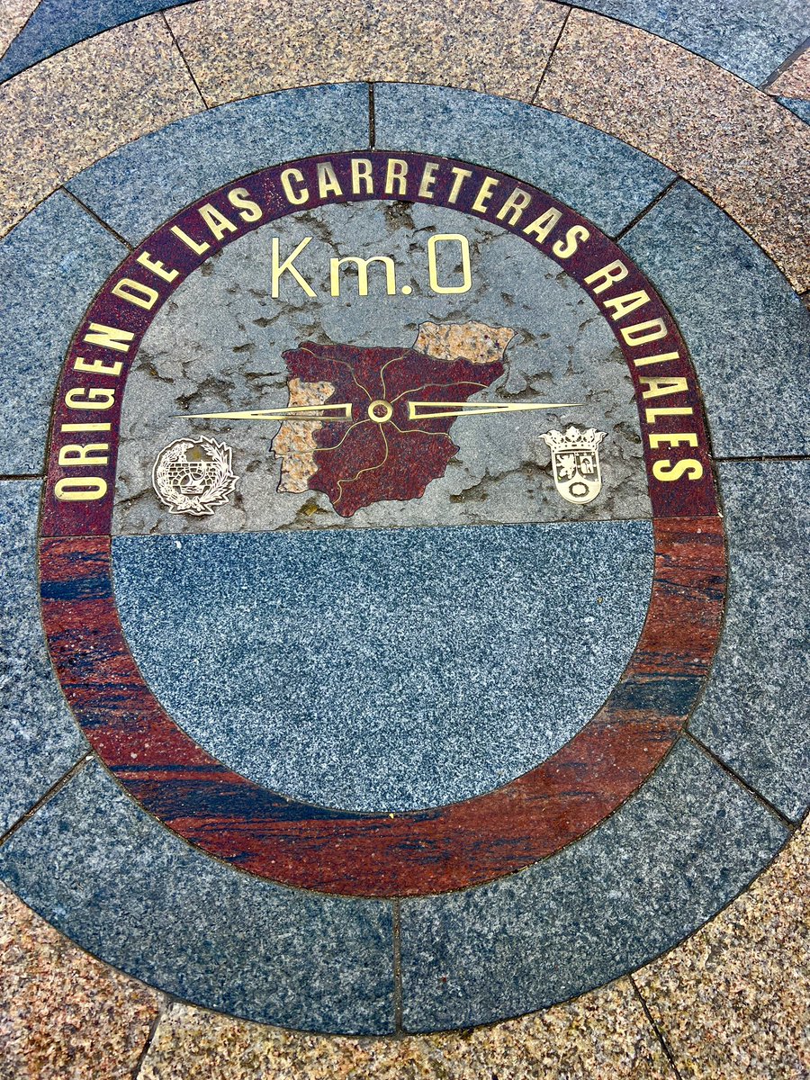 In Puerta del Sol, Madrid, standing on a small stone slab reads, “Origen de las Carreteras Radiales,” or “Origin of the Radial Roads.” This slab, which is most easily identified by the groups of tourists surrounding it, marks the geographical center of Spain 🇪🇸. #spain #madrid