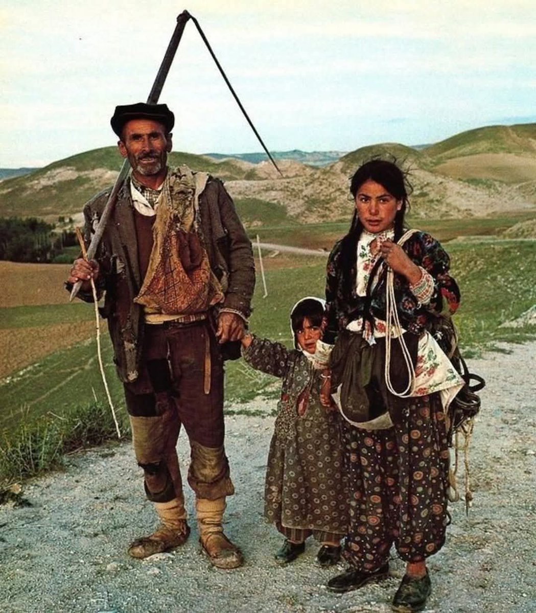 Tarlasından dönerken tırpan taşıyan bir Türk baba ve iki küçük kızı. Sivas, 1960'lı yıllar.