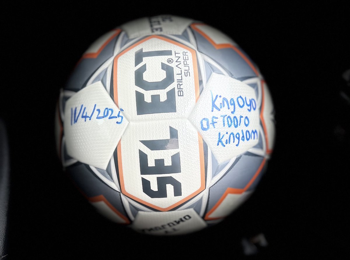 aroriza's tweet photo. The king of Tooro, yesterday, autographed the ball which goals are going to be choreographed today.

@KingOyoOfficial is now going to be at the St. Leo’s Keyegobe pitch today to give permission to  @sc_kalele and @omujuma to try to score goals with his soccer ball in the @ntare_league final game of season 15.

#Road2FortPortal. You can’t make this stuff up.