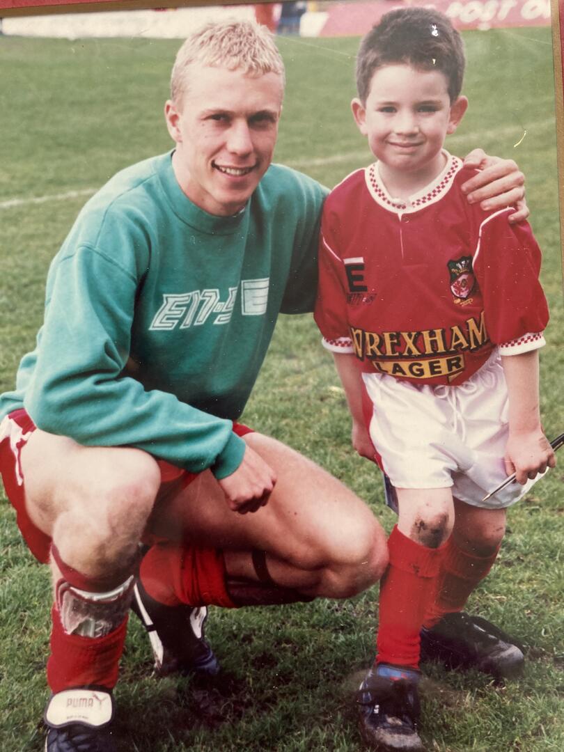 DruidSports's tweet photo. @craigyjones17 My 5 year old son Tomos was the Reds mascot on the day, photo of ticket, Tom with one Stevie Watkin and with the red army in the background.  When having a pre-match kick around he kicked the ball into the air and was looking around for it when it hit him on the top of the head😂 https://t.co/tmcll9Clhu