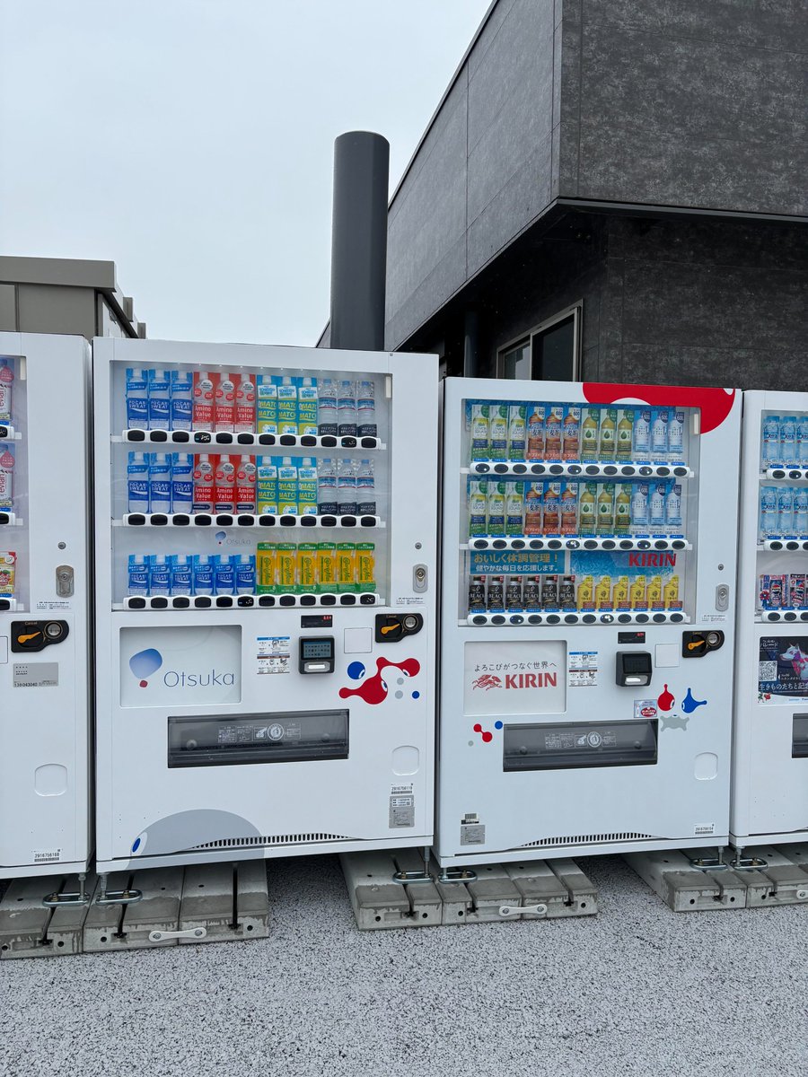 chReed_Oska2025's tweet photo. 万博初日取材がようやく終了。想像以上に疲れ果てました。１３日夢洲は昼ごろから雨だったのですが、風雨のときに来場者が逃げ込める場所があまりにも少ない。それを実感しました。どこかにはあるのかもしれないが、足りないし周知はされていない。屋外の休憩所はびしょびしょで役に��たず、予約制のパビリオンには入れない。ようやく屋内の休憩スペースを見つけてもすでに満員で入場規制がなされていました。飲食店に入ろうにも行列が長い。いったん会場の外に出ようとしたが、そこにも長～い行列。個人的に予約なしで入れるスペースがあることを知っていた大阪ヘルスケアパビリオンも入場規制がなされており、行き詰まりました。

数え切れないほどの来場者がリングの下に避難していましたが、私もどこかに活路はないかと、しばらくリング下をさまよいました。実際にはリングの下にまで雨が吹き込んでいます。行き先を決められずにガタガタ震えてる人が何人もいました。リング下ベンチなど傘をさしながら座っている人が何人もいました。リング下中央のなるべく雨が当たらないあたりの地べたに座り込んで、なんとか��い込んだフードを食べる来場者を、何人もみかけました。私もおにぎりでも買えればよかったのですが、気軽に買い物ができ��状態ではなく、夜まで食事にもありつけませんでした。

放浪の途中、営業施設の２階にちょっとしたスペースを発見し、ここで一息ついてもしかしたら記事も書けるかもしれないと思ったのですが、受付で「ここは関係者入場証（ＡＤ証）をもったものだけが入れるところだ」と断られました。ＡＤ証をもっている人たちは来場者がどんな状況に置かれたか実感できているのでしょうか。

万博遠足の実態も深刻です。万博遠足の児童がお弁当を食べる西の団体休憩所（屋根のみで壁なし）の椅子と少ないテーブルは雨でびしゃびしゃ。目の前には、ガス抜き管がドーンと立っていました。

貸し切りバスで万博遠足にくる児童のルートをたどろうと団体バス乗降場から西ゲートまで歩きましたが、疲労空腹時の暴風に一時、身の危険を覚えました。これについては動画がでるかもしれません。廃棄物由来のガスが大量に発生している地域なので、あちこちにガス抜き管が立ち並んでいました。

西ゲートから本会場に入り、疲れて何か飲もうと近づいた自動販売機の裏にもそれはニュッと立っていました。それが添付の写真です。（他の写真などは赤旗や公式的なアカウントから出されると思います。）
