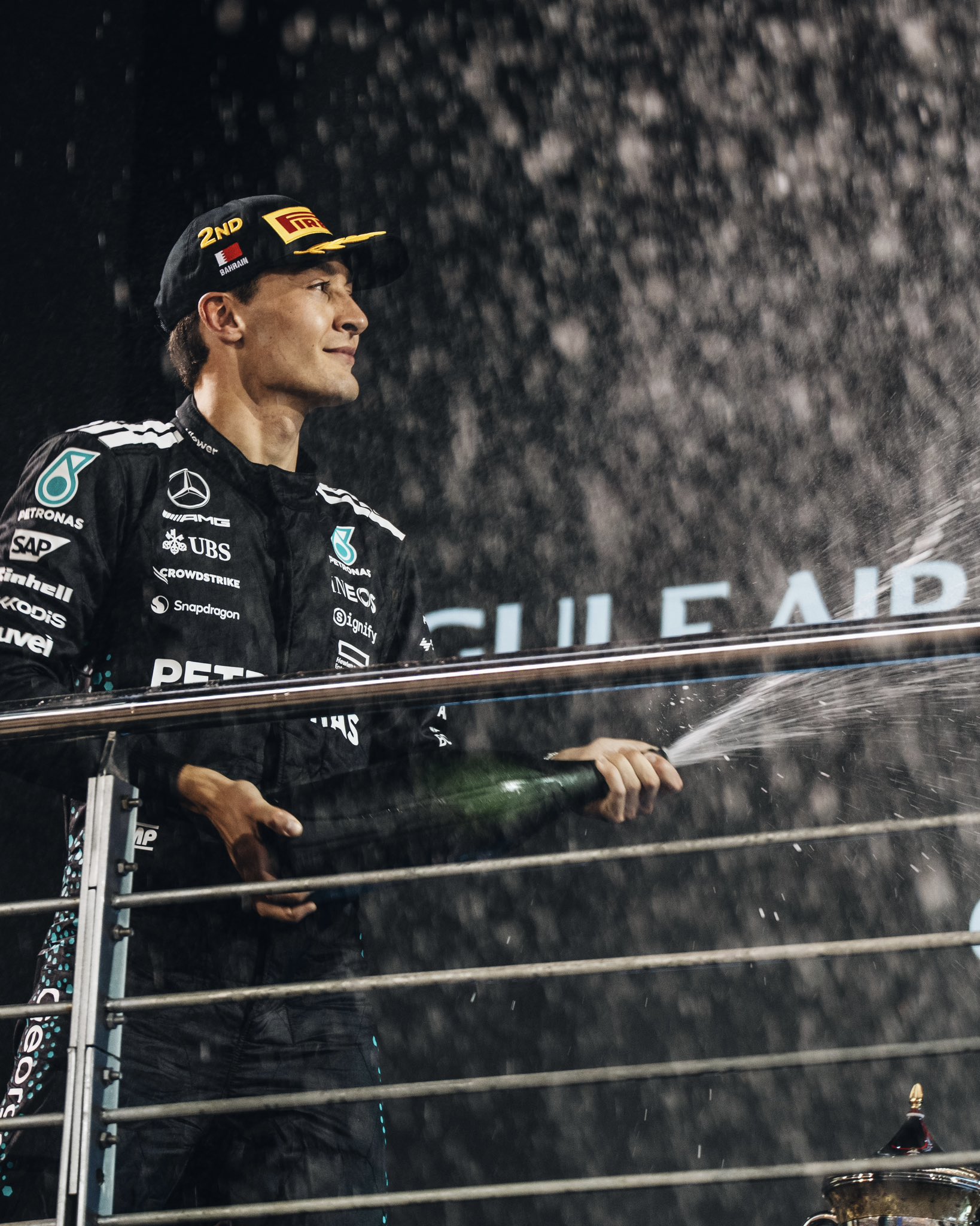 George Russell spraying champagne on the podium in Bahrain