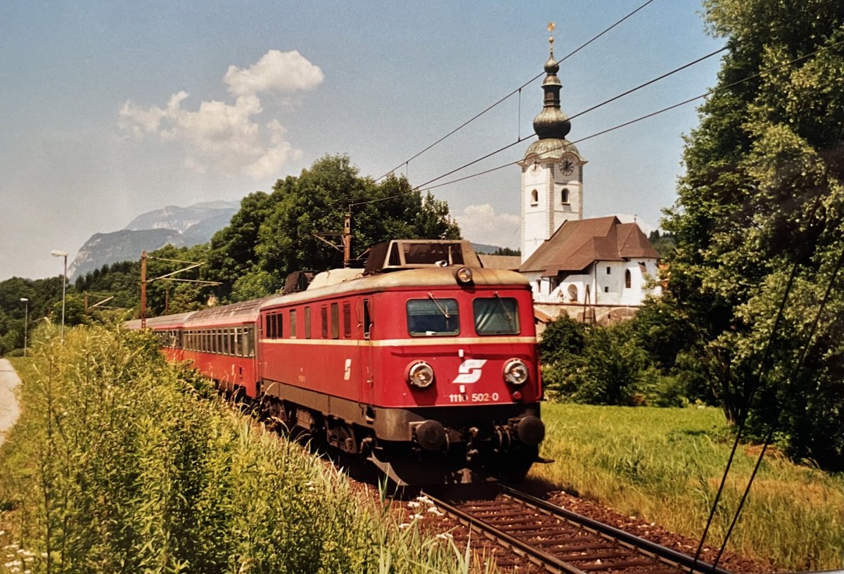 AndreasWiede's tweet photo. #InterCity 291 to #Beograd 🇷🇸 via #Ljubljana 🇸🇮 and #Zagreb 🇭🇷 with through coaches from #Munich 🇩🇪 is seen here at #Finkenstein 🇦🇹 in July 2002. An #ÖBB Class 1110.500 electric is hauling the consist over the #Karawanken #Karavanke line between #Villach 🇦🇹 and #Jesenice 🇸🇮. https://t.co/RgKJ2RsJP3