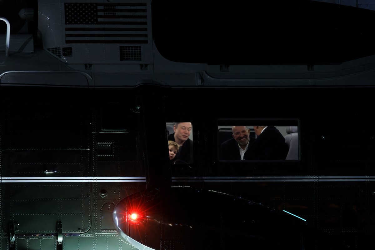 Elon Musk’s son, X Æ A-12, peers out the window of Marine One while sitting beside Commerce Secretary Howard Lutnick and President Donald Trump at Joint Base Andrews in Maryland.