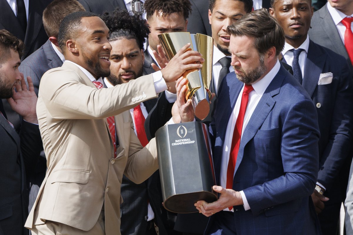 ASchwaTweets's tweet photo. The second before and after: Vice President JD Vance briefly drops the base of the CFP National Championship Trophy  during an event with the 2025 Championship-winning Ohio State University at the White House. (Aaron Schwartz/@SipaUSA) #OhioStateFootball https://t.co/hO3VwGUc5R