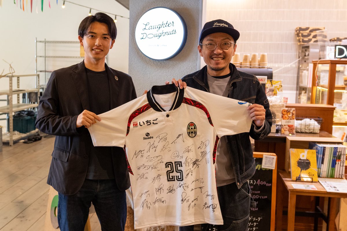 2025年シーズン地域創生パートナーのボードが届きました。あわせて今シーズンのユニフォームも受け取り、担当の爽やかすぎる名執選手と記念に一枚。顔が小さい！！
