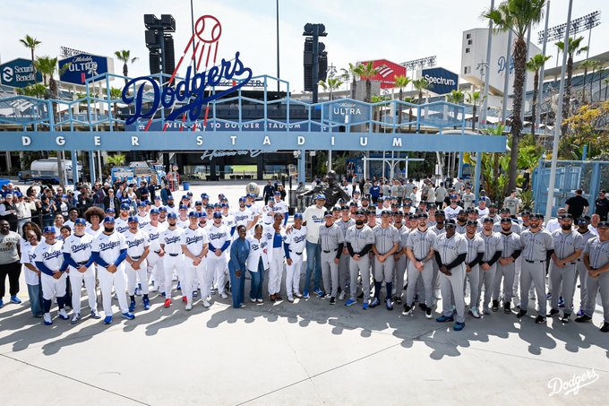 A photo of Dodger players, Rockies players, Kareem Abdul-Jabbar and Jackie Robinson's granddaughter posing for a photo at the Jackie Robinson statue in Centerfield Plaza.