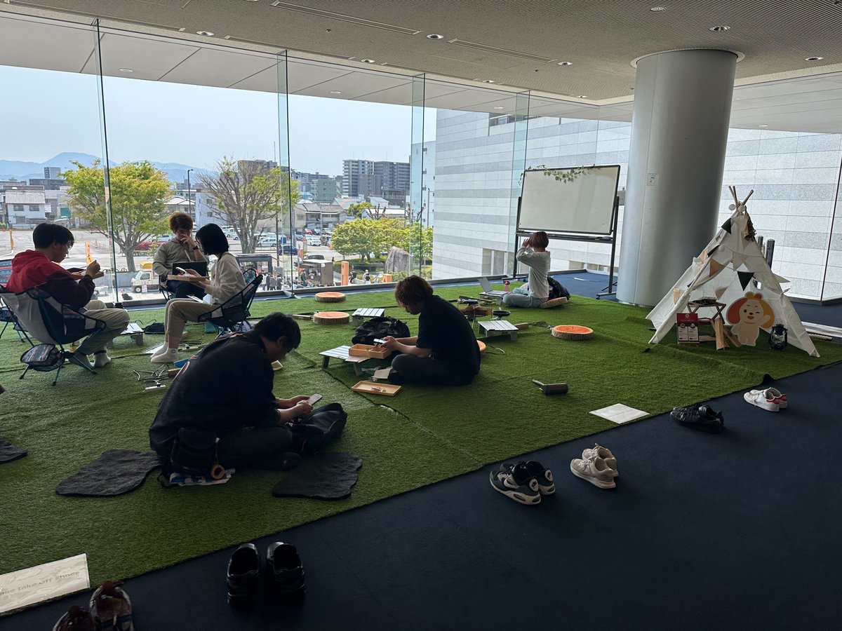 geekneerjp's tweet image. 日光を浴びてランチブレイク中の皆さんが楽しそうにしているのを2F屋内の特設キャンプ風エリアから眺めているみなさんも楽しそうでスポンサーの弊社も楽しいです。エンジニアの皆さんのキャリアを応援しています　＃RubyKaigi2025　スポンサー　＃転職支援　＃ギークニア