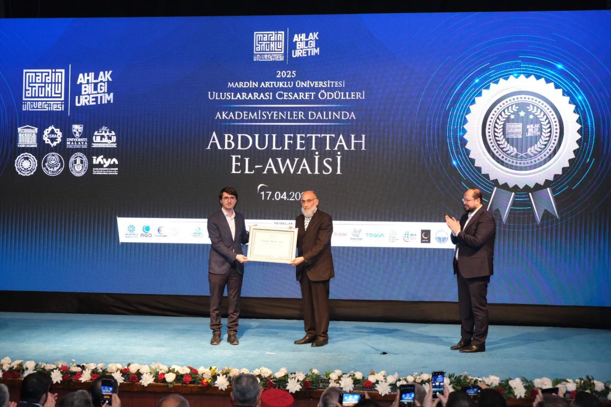 Genel Başkanımız Salih Turhan Bey, Mardin Artuklu Üniversitesi'nin tertip ettiği 25. Beytülmakdis Uluslararası Akademik Sempozyumu ve Uluslararası Cesaret Ödülleri Programı'nda Akademisyenler Dalında ödüle layık görülen Prof. Dr. Abdulfettah El- Awaisi Bey'e plaket takdiminde
