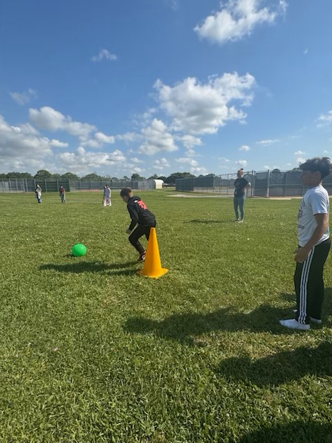 Launch students working on Leader in Me Habit 7 - Sharpen the Saw by taking care of their body with some group exercise playing kick-ball