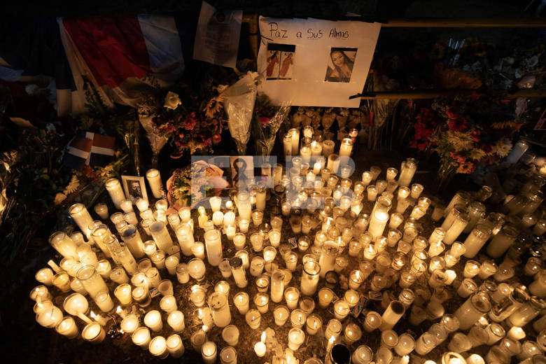observa las candelas. Permanece ensimismada, oteando todo en silencio. Mantiene siempre los brazos cruzados contra su pecho, y entre ellos, un papel.
De vez en cuando mueve los brazos de la misma forma en que se mece a un bebé.