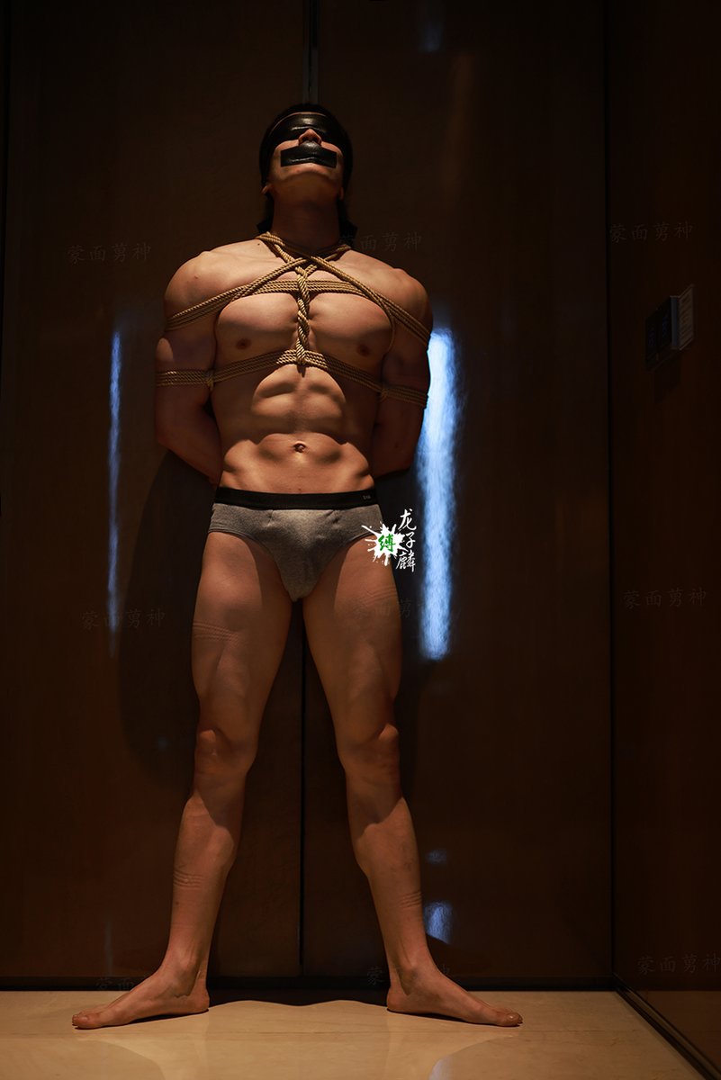 寸头爷们，体脂低得像块雕刻的岩石，腹肌线条分明。被捆后绳子勒着手臂与胸膛，每一块肌肉都紧绷着，肌肉因挣扎而鼓起。像是头被困的猛兽，透着股不屈的野心性。仿佛想要挣脱束缚，爆发而出。