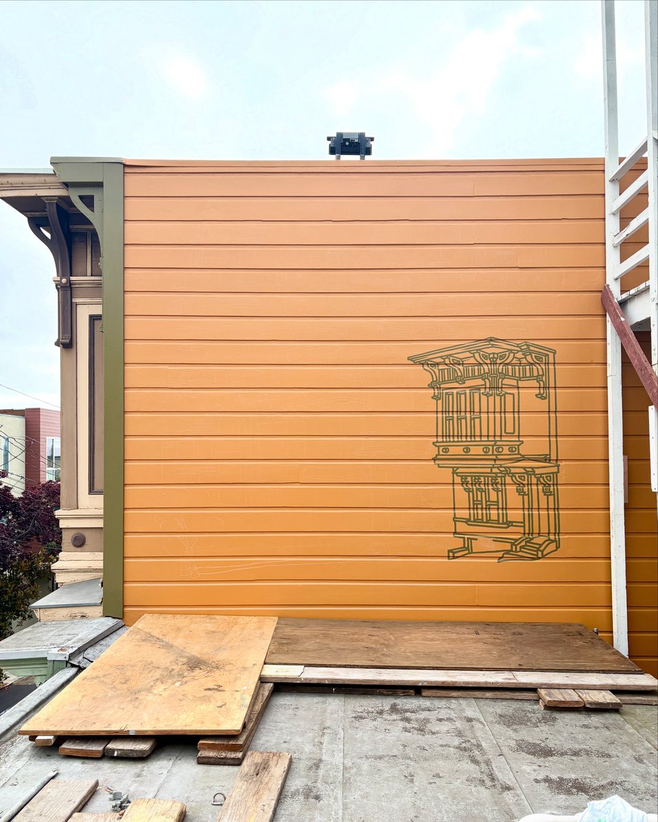 Painting of a house on the side of itself. New mural on Hickory Alley