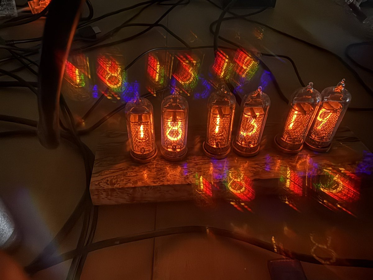 Nixie tube clock photographed through diffraction grating. The blue is probably from mercury vapor. The red and yellow are from neon (and probably agon).