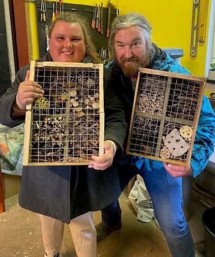 Thanks to #welshwatercommunityfund we are focusing on a Bees, Butterflies &amp; Birds Project this year. Our new bug hotels are almost ready, &amp; we have lots of fantastic plants ready soon to attract pollinating insects &amp; birds. Here are Fiona and Tom modelling our crafty creations.