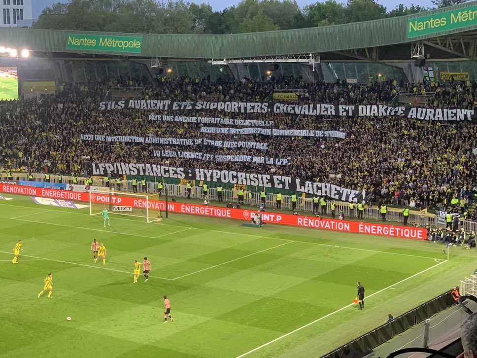 ActuFoot_'s tweet photo. La banderole nantaise suite aux fumigènes tenus par Lucas Chevalier et Bafodé Diakité après une rencontre 🎇🧨 :

« 𝗦’𝗶𝗹𝘀 𝗮𝘃𝗮𝗶𝗲𝗻𝘁 𝗲́𝘁𝗲́ 𝘀𝘂𝗽𝗽𝗼𝗿𝘁𝗲𝗿𝘀, 𝗖𝗵𝗲𝘃𝗮𝗹𝗶𝗲𝗿 𝗲𝘁 𝗗𝗶𝗮𝗸𝗶𝘁𝗲́ 𝗮𝘂𝗿𝗮𝗶𝗲𝗻𝘁 𝗽𝗮𝘆𝗲́ 𝘂𝗻𝗲 𝗮𝗺𝗲𝗻𝗱𝗲 𝗳𝗼𝗿𝗳𝗮𝗶𝘁𝗮𝗶𝗿𝗲 𝗱𝗲́𝗹𝗶𝗰𝘁𝘂𝗲𝗹𝗹𝗲,
𝗿𝗲𝗰̧𝘂 𝘂𝗻𝗲 𝗶𝗻𝘁𝗲𝗿𝗱𝗶𝗰𝘁𝗶𝗼𝗻 𝗰𝗼𝗺𝗺𝗲𝗿𝗰𝗶𝗮𝗹𝗲 𝗱𝗲 𝘀𝘁𝗮𝗱𝗲,
𝗿𝗲𝗰̧𝘂 𝘂𝗻𝗲 𝗶𝗻𝘁𝗲𝗿𝗱𝗶𝗰𝘁𝗶𝗼𝗻 𝗮𝗱𝗺𝗶𝗻𝗶𝘀𝘁𝗿𝗮𝘁𝗶𝘃𝗲 𝗱𝗲 𝘀𝘁𝗮𝗱𝗲 𝗮𝘃𝗲𝗰 𝗽𝗼𝗶𝗻𝘁𝗮𝗴𝗲,
𝘃𝘂 𝗹𝗲𝘂𝗿 𝗹𝗶𝗰𝗲𝗻𝗰𝗲 𝗙𝗙𝗙 𝘀𝘂𝘀𝗽𝗲𝗻𝗱𝘂𝗲 𝗽𝗮𝗿 𝗹𝗮 𝗟𝗙𝗣.

𝗟𝗙𝗣/𝗜𝗻𝘀𝘁𝗮𝗻𝗰𝗲𝘀 : 𝗵𝘆𝗽𝗼𝗰𝗿𝗶𝘀𝗶𝗲 𝗲𝘁 𝗹𝗮̂𝗰𝗵𝗲𝘁𝗲́ ! »

📸 @MattMargueritte
