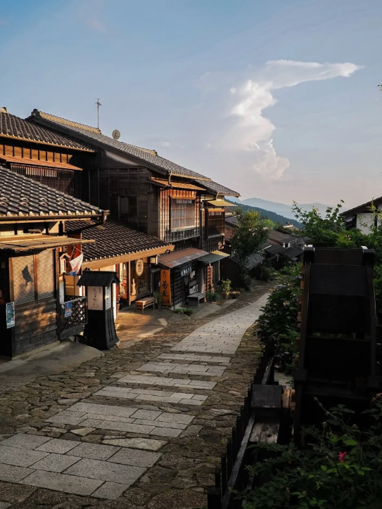 屋根は黒い瓦で覆われ、遠くの山々には雲がかかって、まるで静かな絵巻物のようでした。まるで昔にタイムスリップしたような、歴史と自然の調和を感じることができます。あなたもこの小道を歩いて、風の音を聞きたいですか?#旅#歴史#自然美です