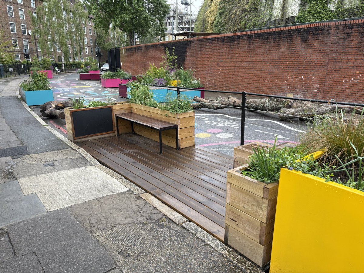 Currently visiting London and I found a great school street in Vauxhall with a traffic diverter, lots of seating, felled tree trunks for climbing, cargo bike parking, and plenty of plants and bright colors to create a welcoming atmosphere.