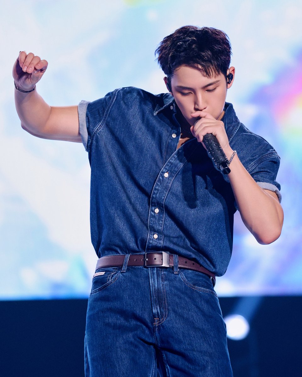 denim on stage. MINGYU wears Calvin Klein at the Japan fan performance in Osaka.​ the look is tucked in for definition.
