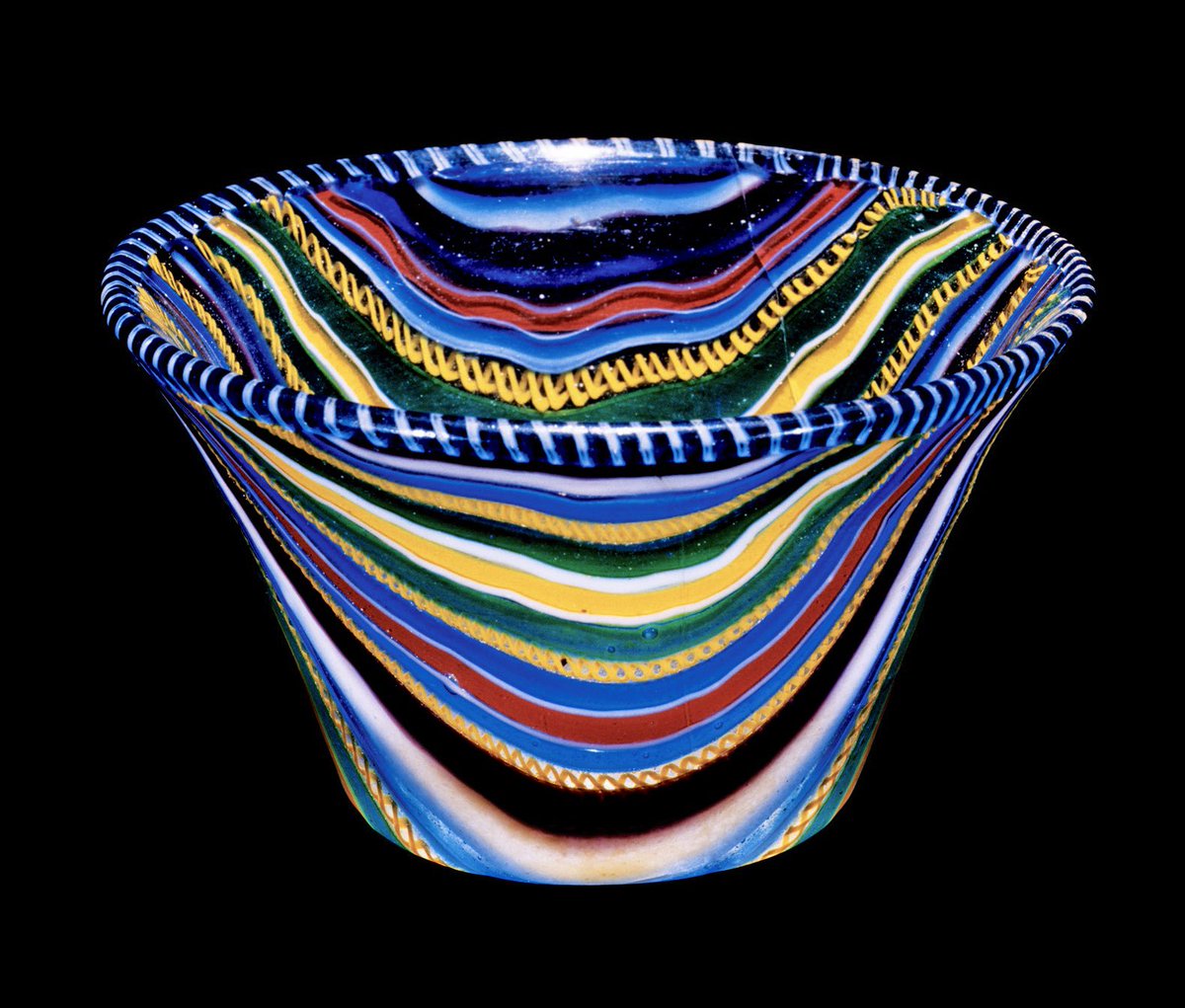 Roman ribbon glass cup: this dazzling style of mosaic glass became fashionable in the 1st century, made with numerous glass canes fused together. The glass was then heated, softened and slumped over a mold, forming spectacular vessels like this cup. 25 BC-50 AD, Corning Museum