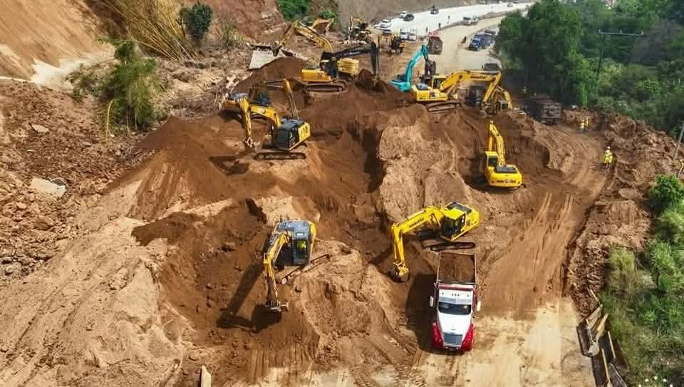 alertanoti's tweet photo. VISTA AÉREA DEL DESLIZAMIENTO DE TIERRA EN CARRETERA LOS CHORROS; VÍA SOTERRADA COMPLETAMENTE 

El derrumbe en  kilómetro 16, de la carretera Los Chorros, abarca ambos carriles. 

El paso hacia Santa Tecla esta suspendido desde Lourdes.

Los equipos del Ministerio de Obras Públicas  retiran con maquinaria el deslizamiento de tierra, que ocurrió esta madrugada.

El personal trabaja para despejar el sector, garantizando la seguridad vial.

Afortunadamente, no hay víctimas mortales.