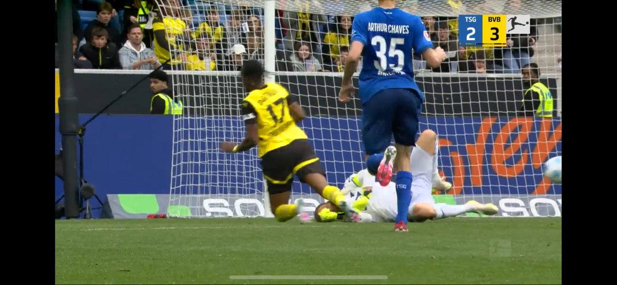 Was die Szene (und auch andere Wiederholungen) zeigen: 
Baumann spielt zuerst Chukwuemeka bevor der Ball von ihm abprallt und Chukwuemeka ihn im Fallen trifft. Das ist ein Elfmeter, wenn Anton kein Tor in der Folge macht.